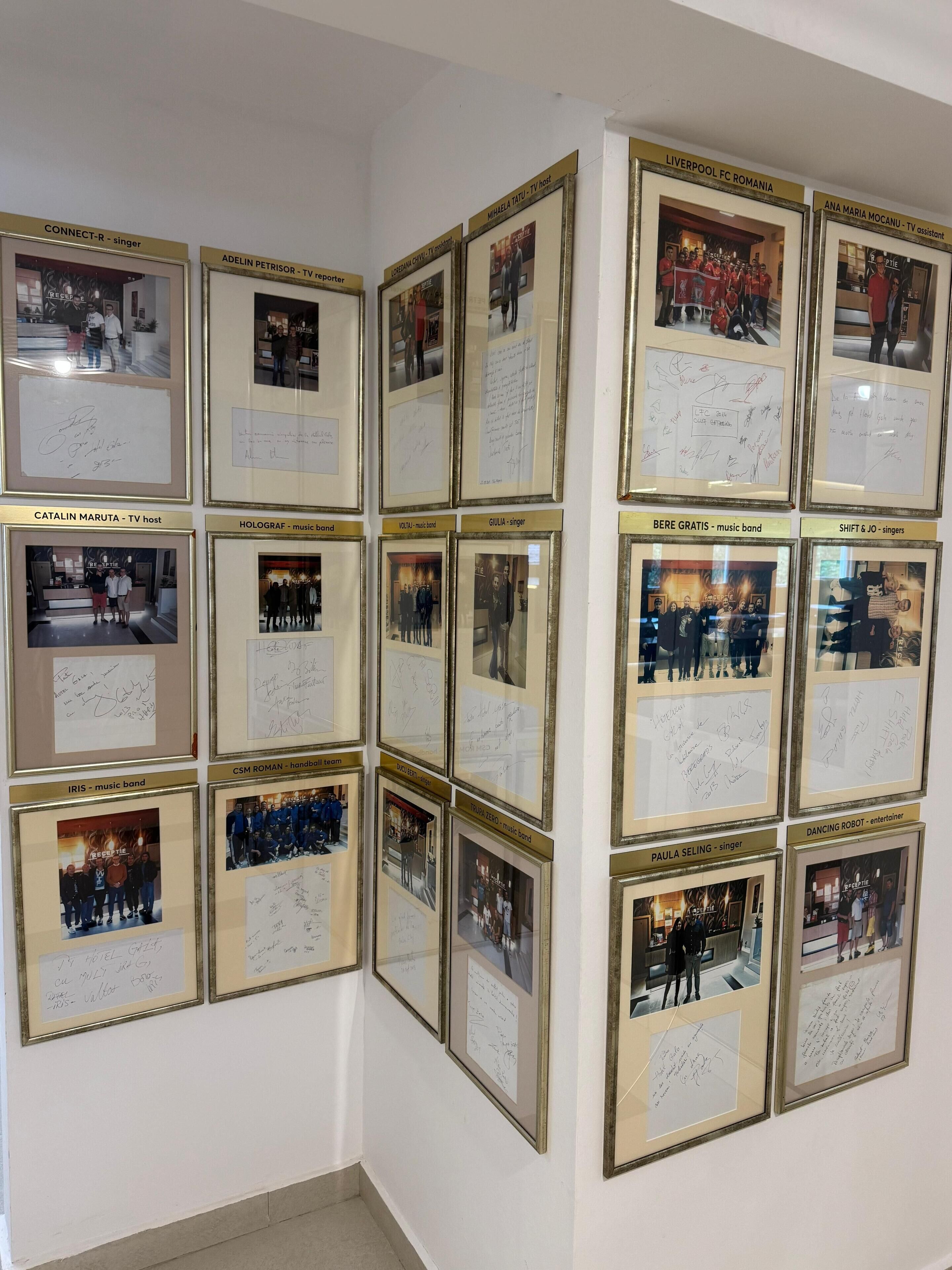 Un mur orné de photos encadrées et de dédicaces de divers artistes et groupes de musique.