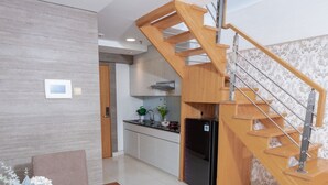 Een moderne keuken met een houten trap die naar een hoger gelegen niveau leidt.