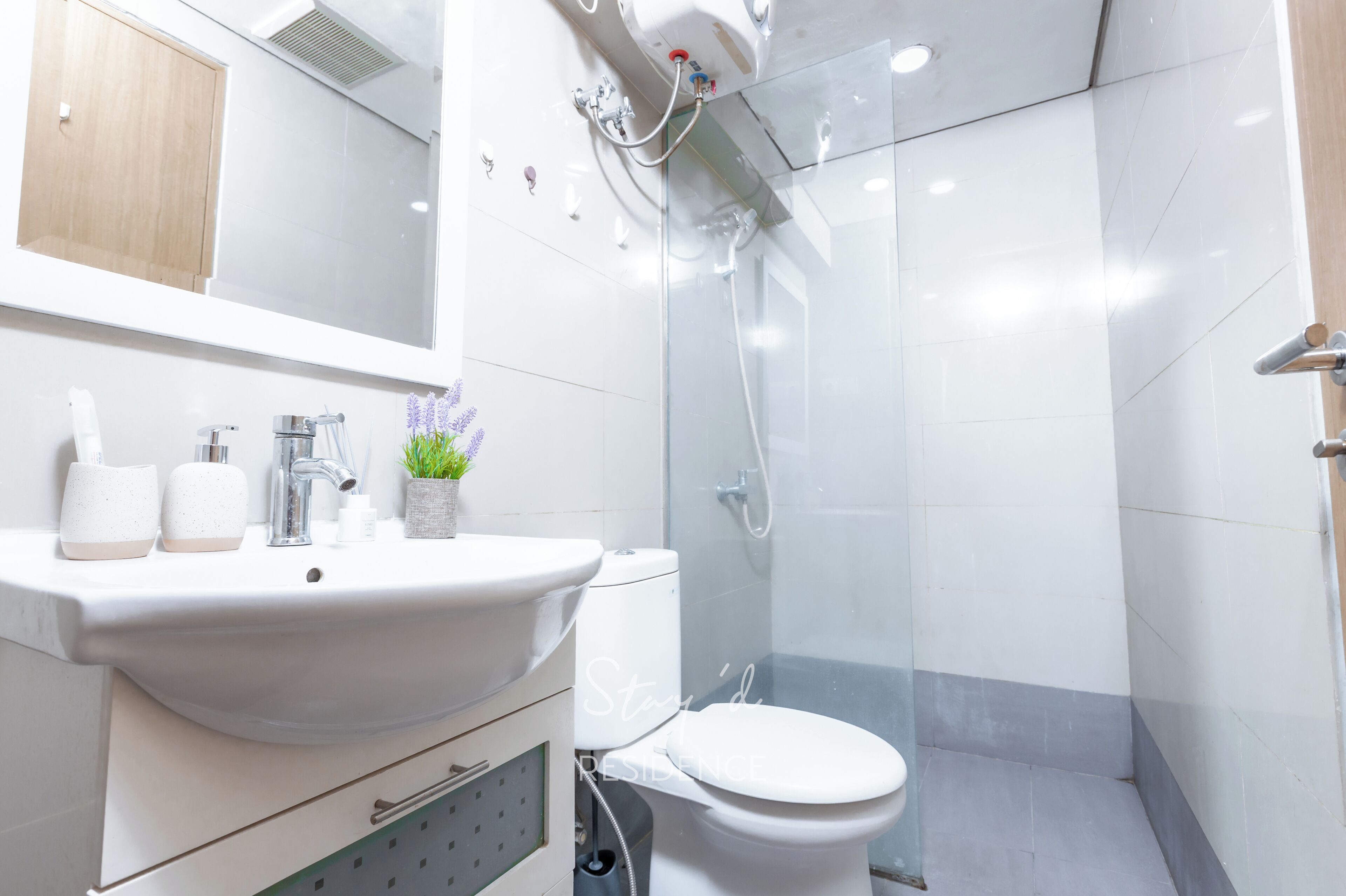 A modern bathroom with a white sink, toilet, and shower.