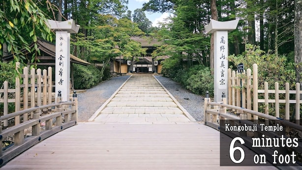Een traditionele Japanse tempelpoort met houten leuningen en een stenen pad dat naar de tempel leidt.