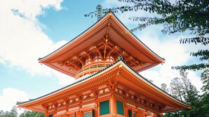Een traditioneel Japans gebouw met een groot, versierd dak en een trap die er naartoe leidt.