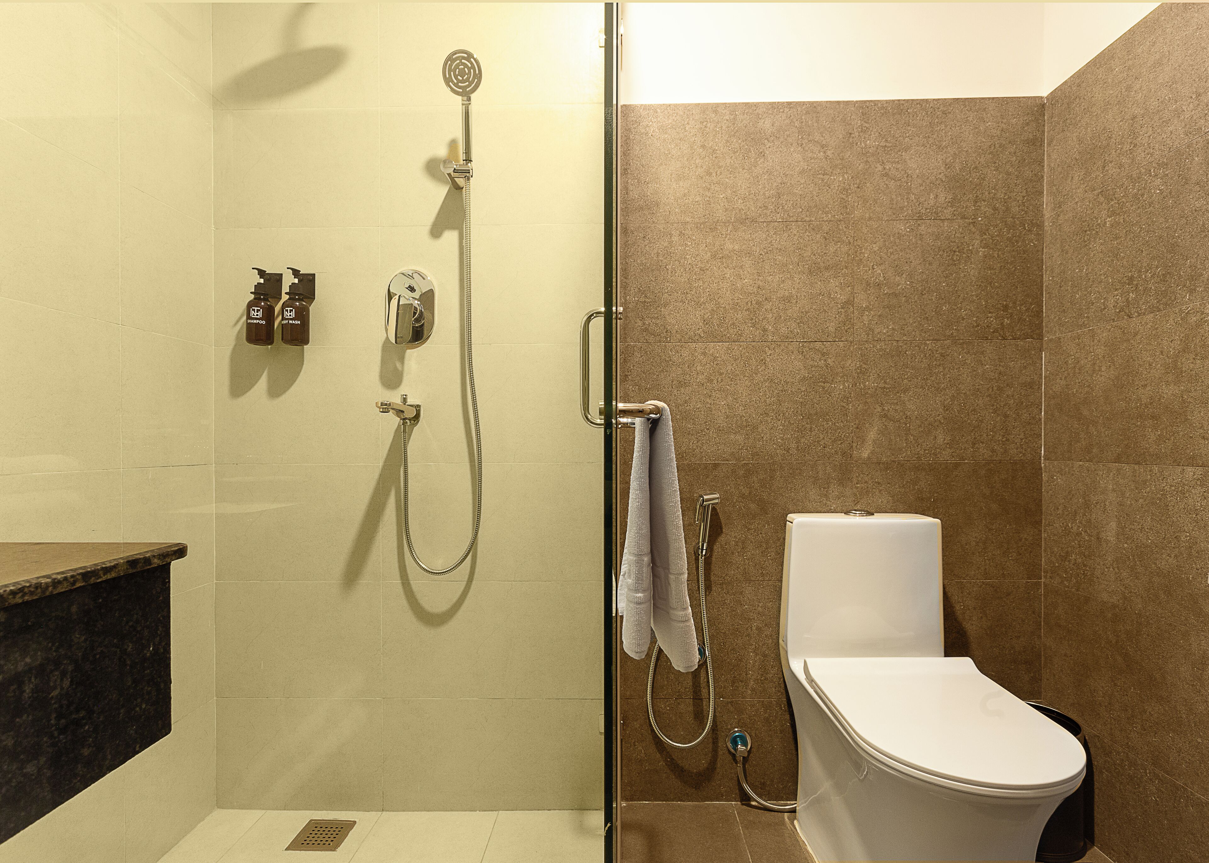 A bathroom with a shower, toilet, and a towel rack.