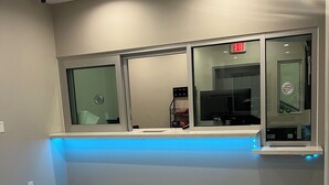 A hotel reception area with a counter, a security camera, and an exit sign. - Crystal Inn - NorthWest - 290 (Houston)