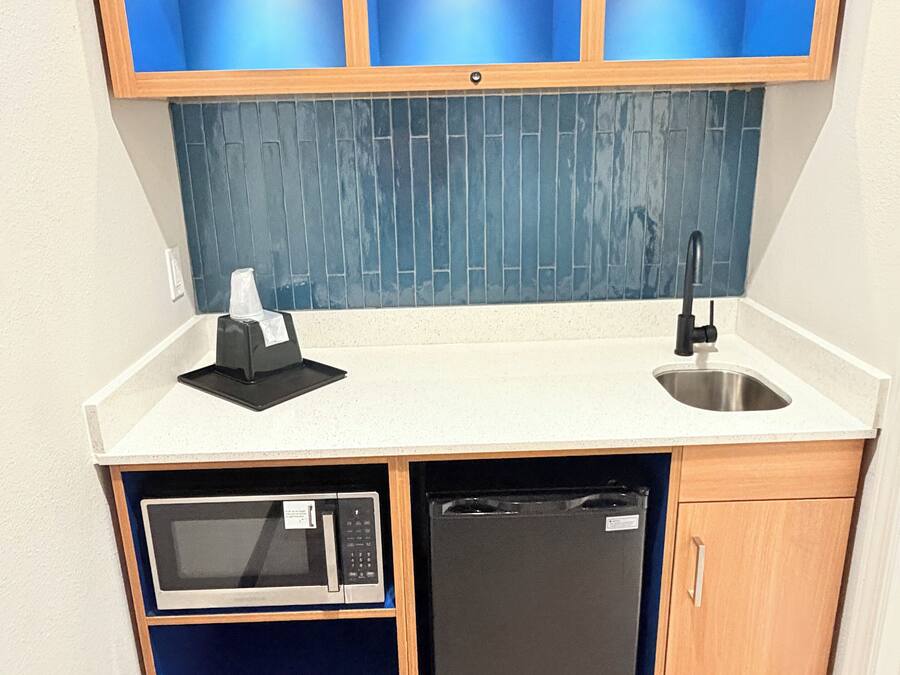 A compact kitchen with a built-in microwave, dishwasher, and a sink.
