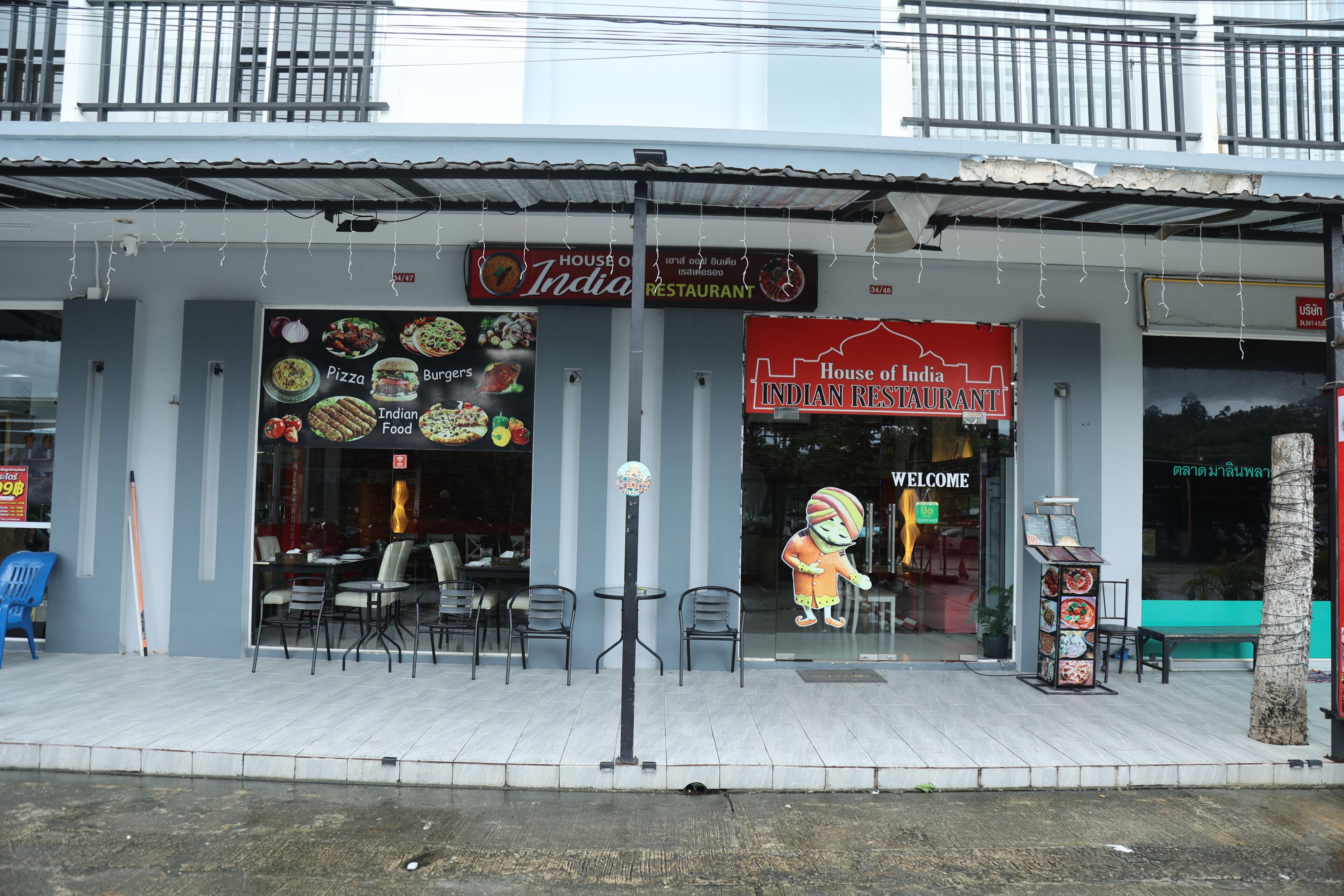 A restaurant with a signboard displaying various dishes and a cartoon character.