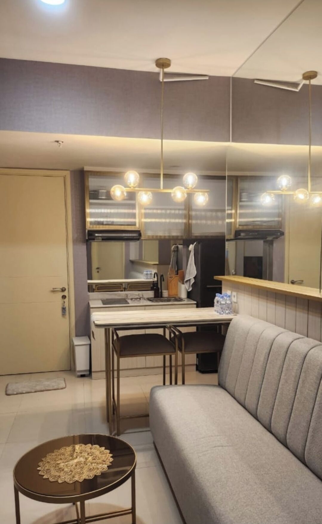 Una cocina moderna con comedor, un sofá y una pequeña mesa con un objeto decorativo.