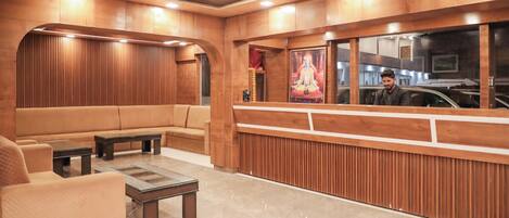 A reception area with a wooden reception desk, leather seating, and a glass coffee table.