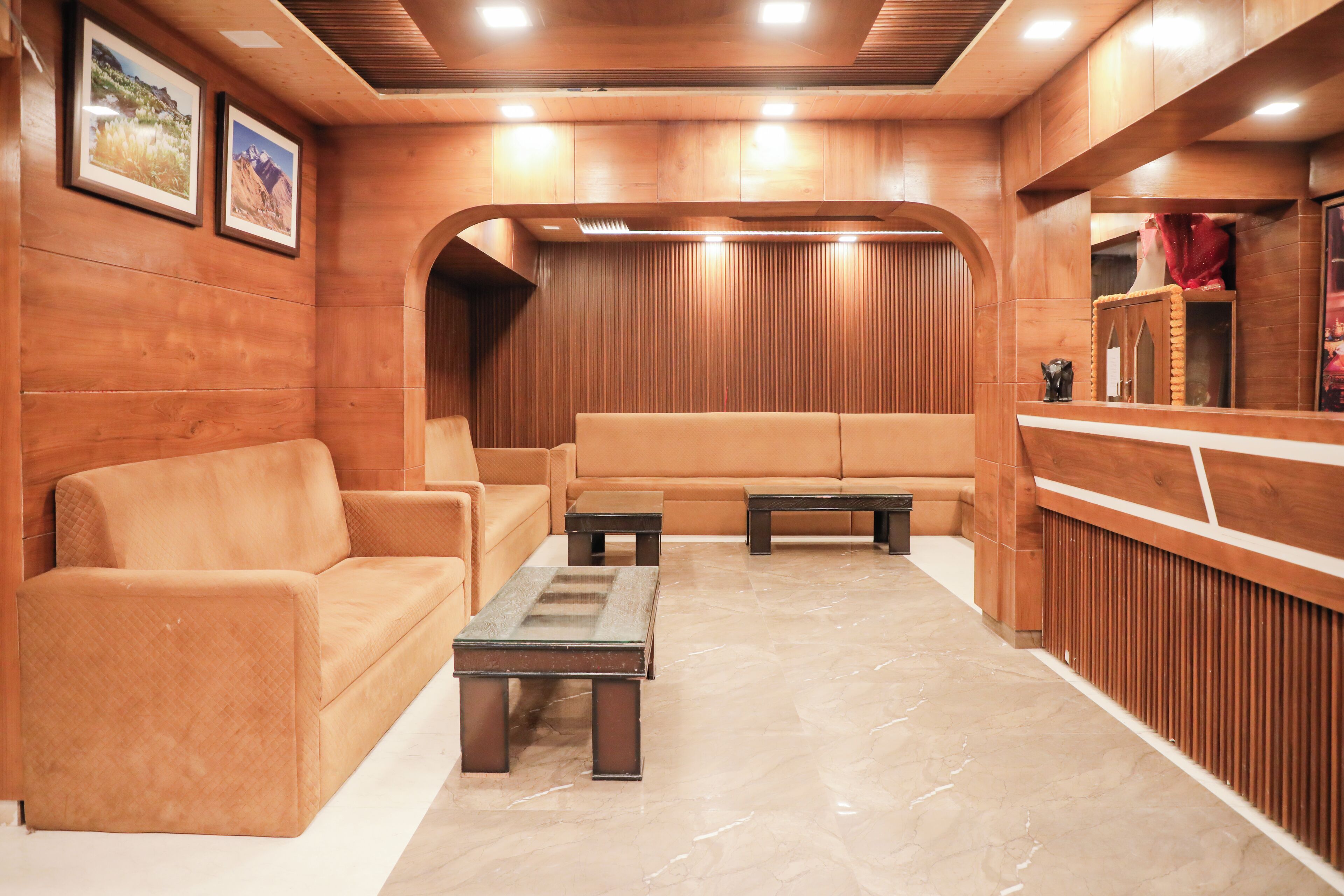 A lobby with wooden paneling, a reception desk, a sofa, and a coffee table.