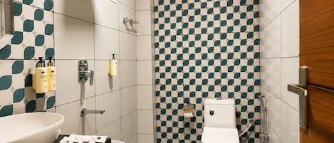 A modern bathroom with a checkered tile wall, a sink, toilet, and a shower.