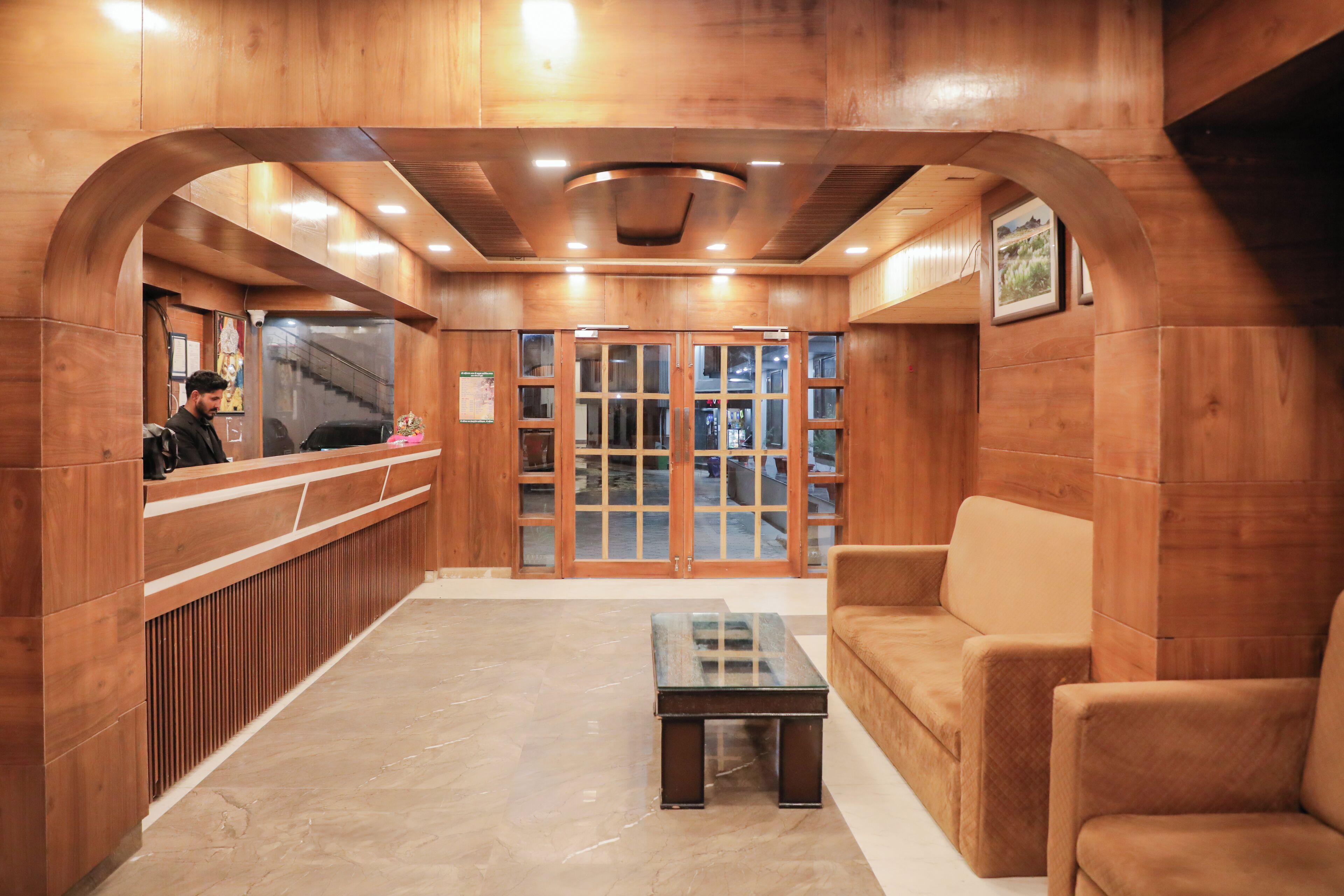 A reception area with wooden walls, a reception desk, a sofa, and a coffee table.