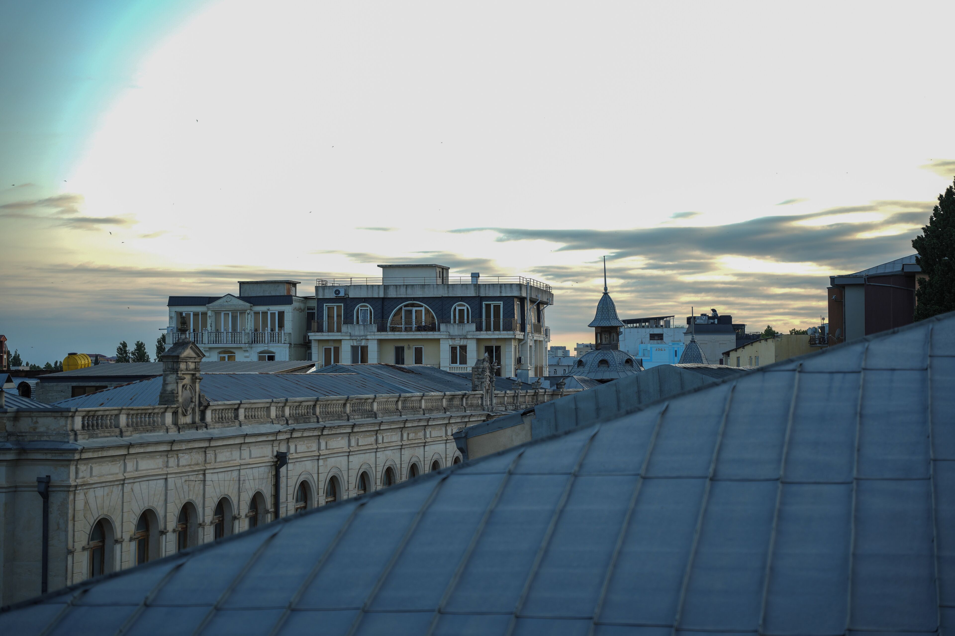 A historic building with a central dome and arched windows, surrounded by other structures.