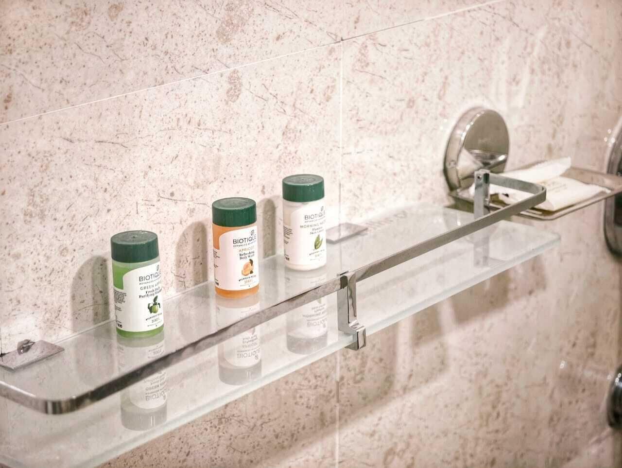 A bathroom shelf with three toiletry bottles.
