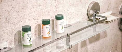 A bathroom shelf with three toiletry bottles.