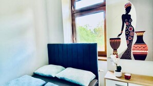Een slaapkamer met een bed, nachtkastje, kast en raam.