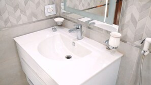 A bathroom with a large white sink, two faucets, and a mirror above it. - Premium Swiss Residence Mohandessin (Cairo)