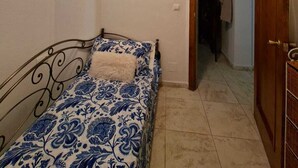 A bedroom with a bed, a painting on the wall, and an open door leading to another room. - Fantastic apartment in La Manga Club. Swimming pool, restaurants, pubs, golf beach (Cartagena)