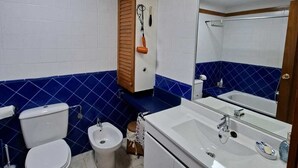 A bathroom with a toilet, bidet, sink, and mirror. - Fantastic apartment in La Manga Club. Swimming pool, restaurants, pubs, golf beach (Cartagena)
