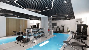 A modern gym with various exercise equipment, a blue floor, and a wooden wall with the text "MEILING". - Surxondaryo Hotel (Tashkent)