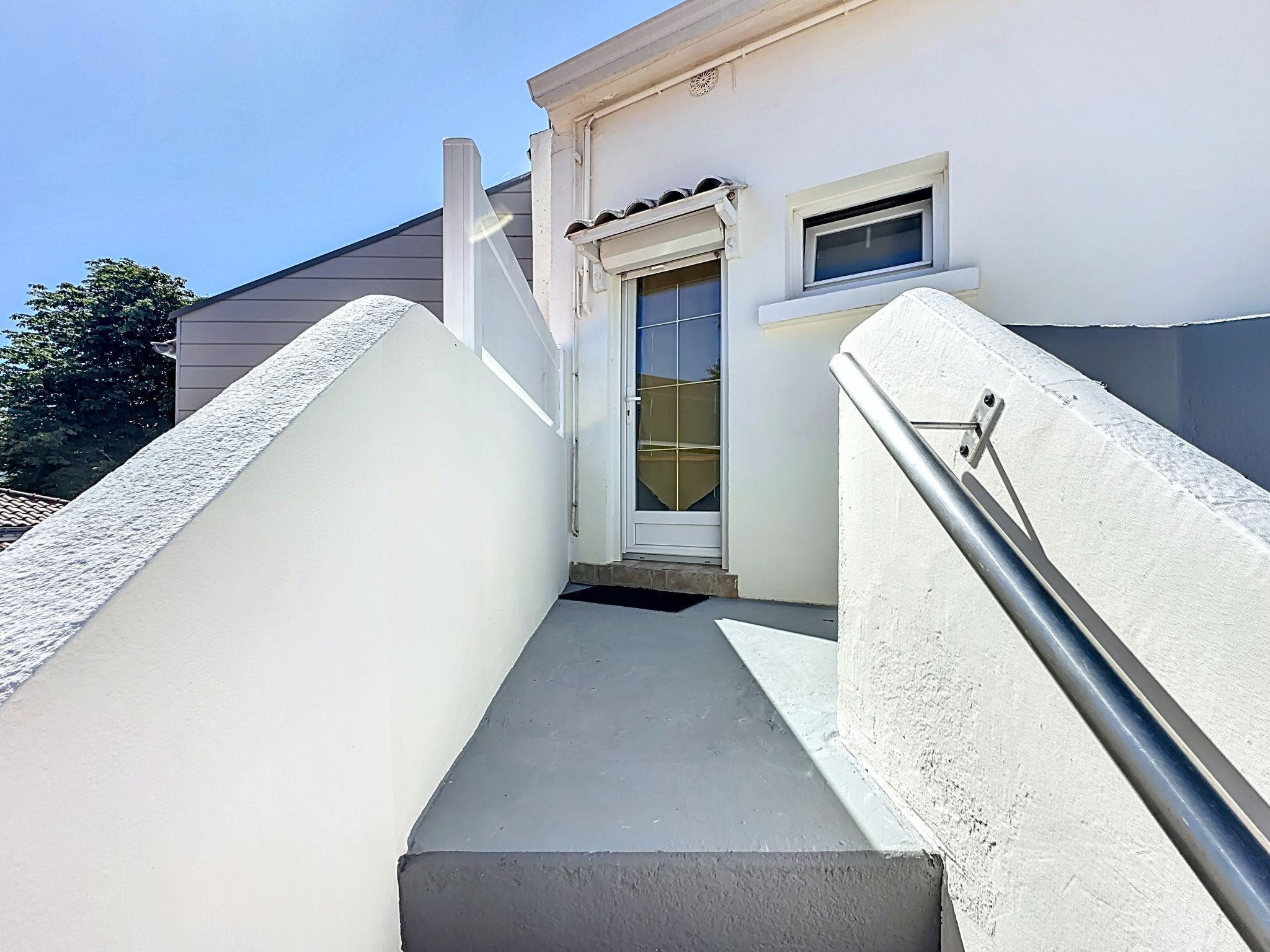 A narrow stairway leading to a white door with a small window above it.