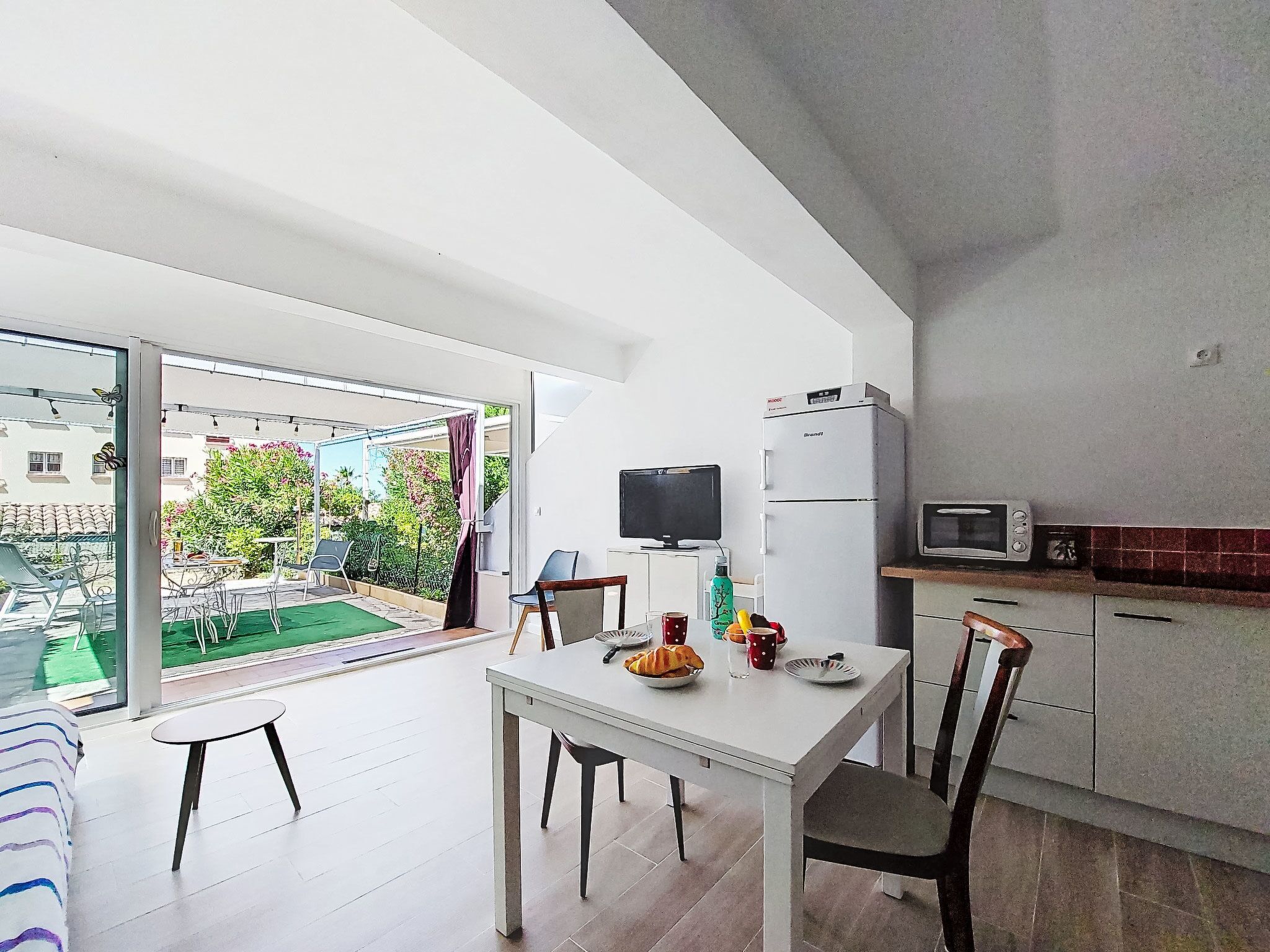Una cucina moderna con frigorifero, microonde e zona pranzo con tavolo e sedie.