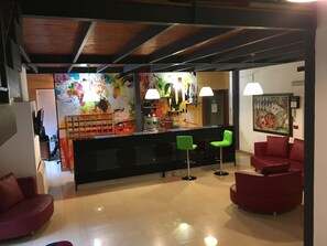 A modern interior with a bar area, red seating, and abstract art on the walls. - Centrale (Syracuse)