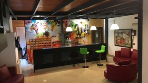 A modern interior with a bar area, red seating, and abstract art on the walls.