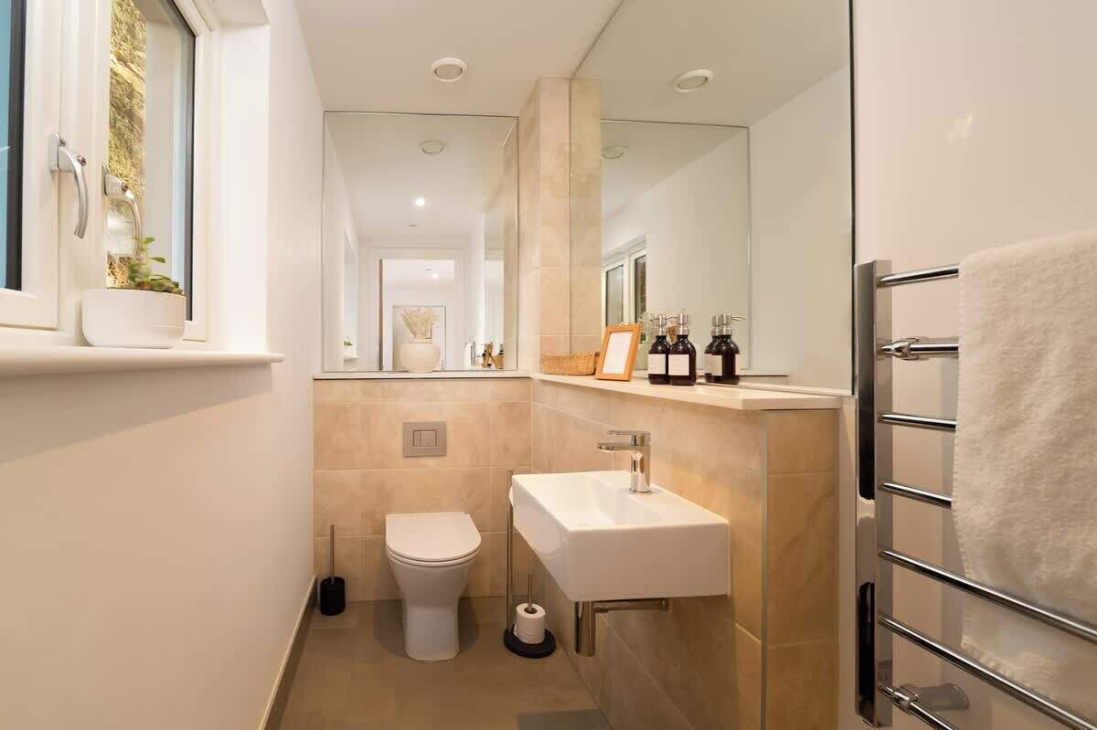 Un bagno moderno con il water, il lavandino e un porta asciugamani.