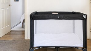 Une pièce avec une poussette pour bébé noire et une porte blanche.