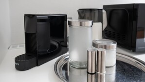 A kitchen area with a coffee maker, a microwave, and a set of condiment containers on a tray. - Guesthouse Elena Apartment 13 (Kassel)