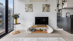 A modern living room with a flat-screen TV, a white entertainment unit, and artwork on the wall. - Luxury Living in Heart of South Yarra near Jam Factory, Prahran Market Chapel St (South Yarra)