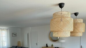 Ein modernes Wohnzimmer mit einem großen Esstisch aus Holz, einem blauen Sofa und einer Holzkommode.