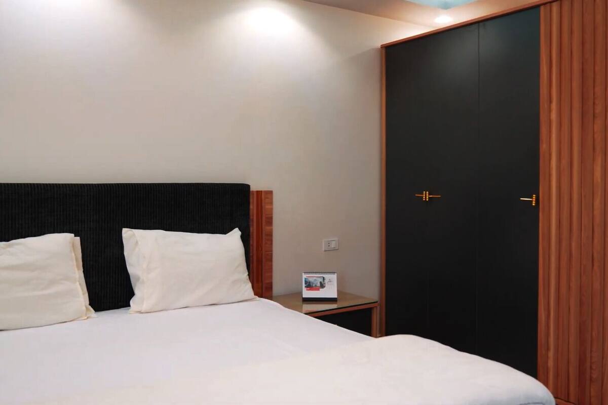 A hotel room with a bed, a nightstand, and a wardrobe.