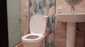 Ein Badezimmer mit Toilette, Waschbecken und Dusche.