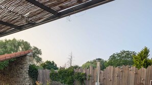 Eine Holzterrasse mit Whirlpool, Steinmauern und einem Holzzaun.