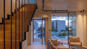 A modern interior with a wooden staircase, a sofa, and a table.