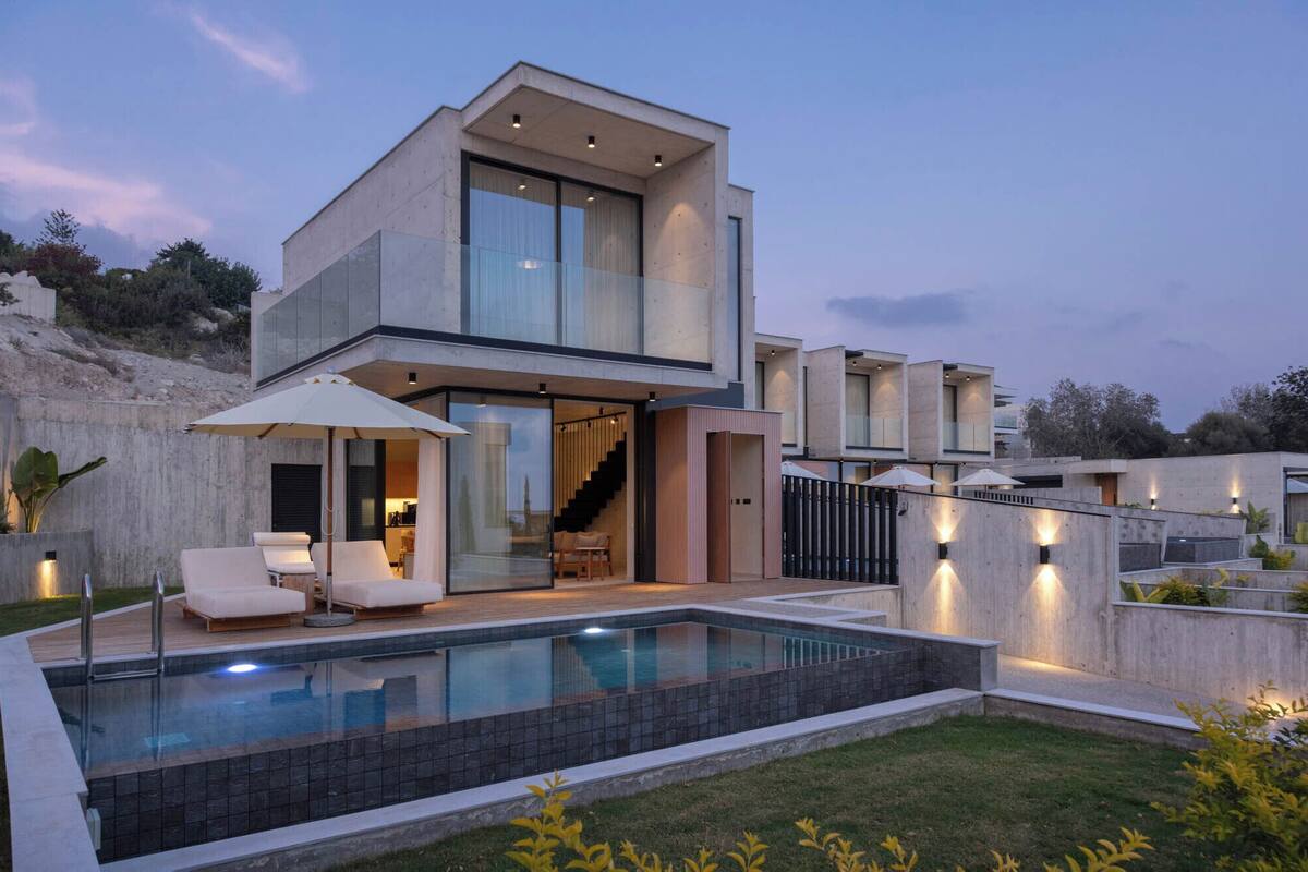 A modern two-story house with a swimming pool, outdoor seating, and a staircase leading to the upper floor.