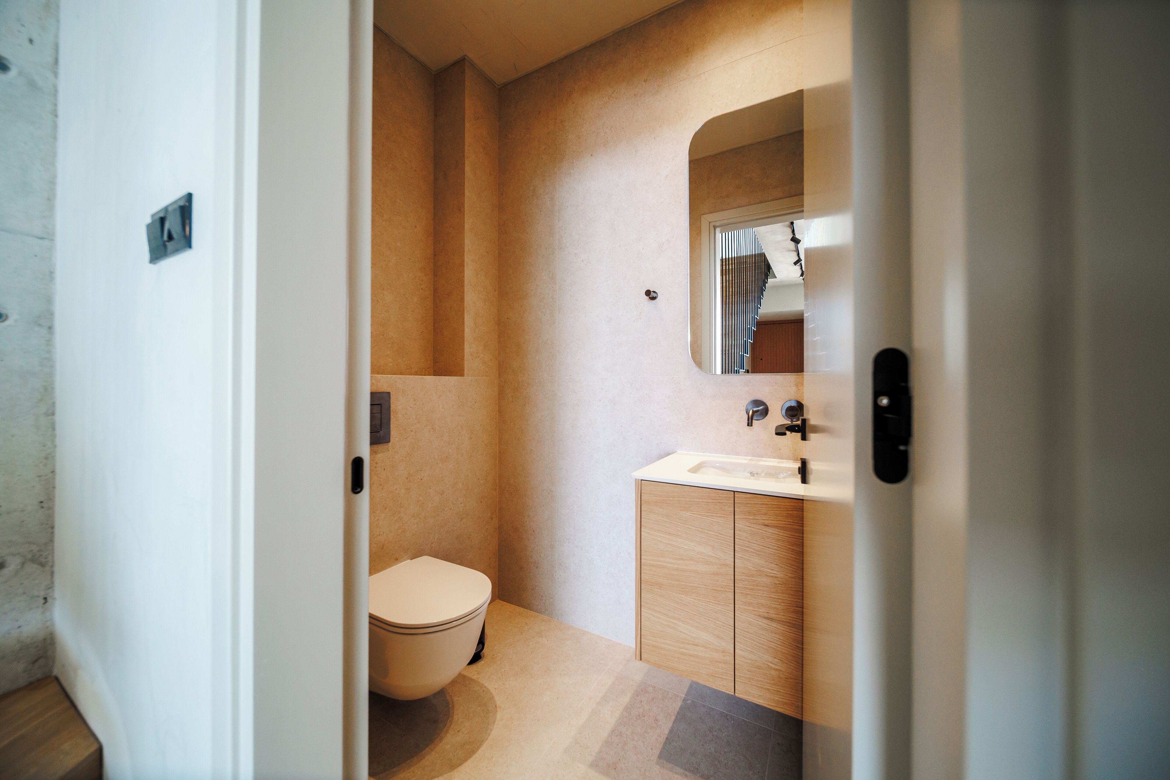 Un bagno moderno con il water, un lavandino e uno specchio.