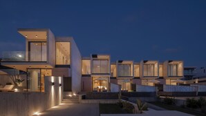 A modern multi-story residential building with large windows and a well-lit exterior.
