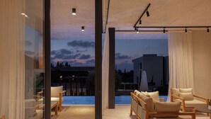 A modern interior with a pool view, wooden furniture, and large windows.