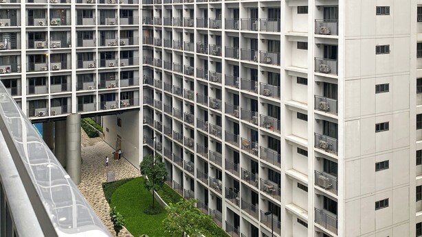A high-rise residential building with multiple balconies, a central courtyard with a pool, and a modern architectural design.