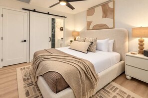 A bedroom with a bed, bedside tables, a ceiling fan, and a wall-mounted artwork. - Casa Del Rey Old Town Retreat | Pool & Casita (Scottsdale)