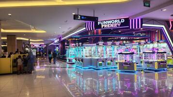 A Funworld Frenzy arcade with claw machines and neon lights.