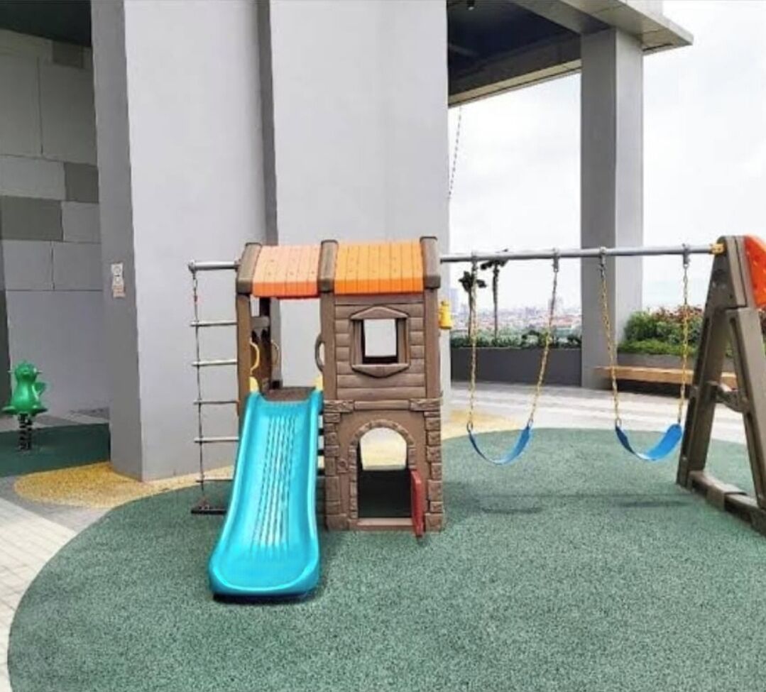 A children's play area with a slide, swings, and a climbing structure.