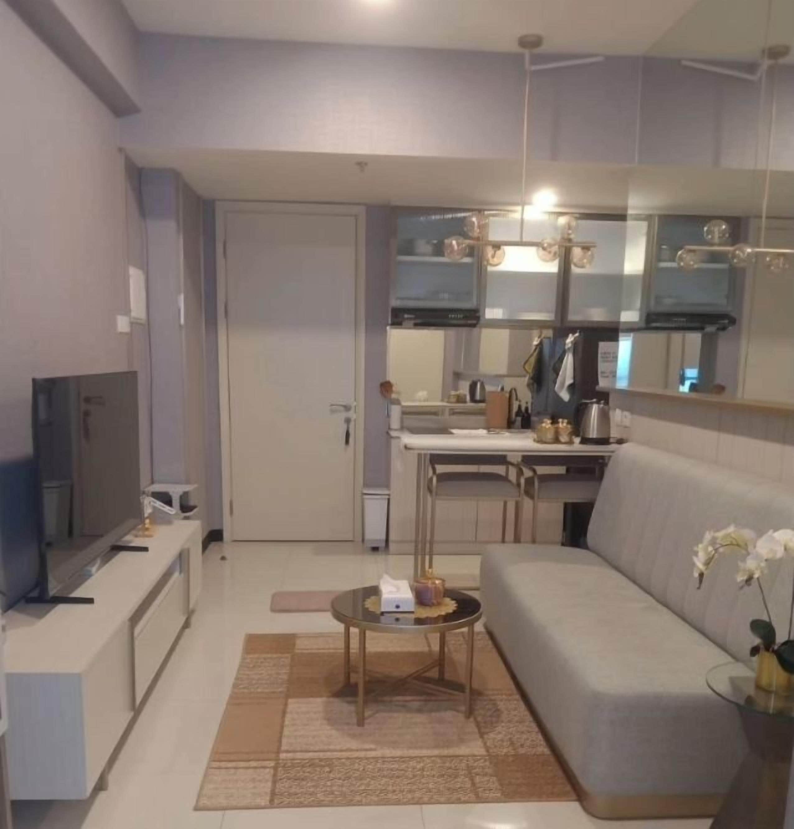 A modern living room with a sofa, coffee table, and a flat-screen TV.