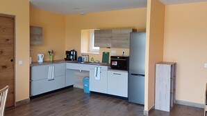 Una cocina compacta con armarios de madera, cafetera y refrigerador.