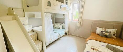 Un dormitorio con literas, un escritorio y una cama con almohada.