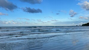 Une plage avec des vagues et un ciel dégagé.