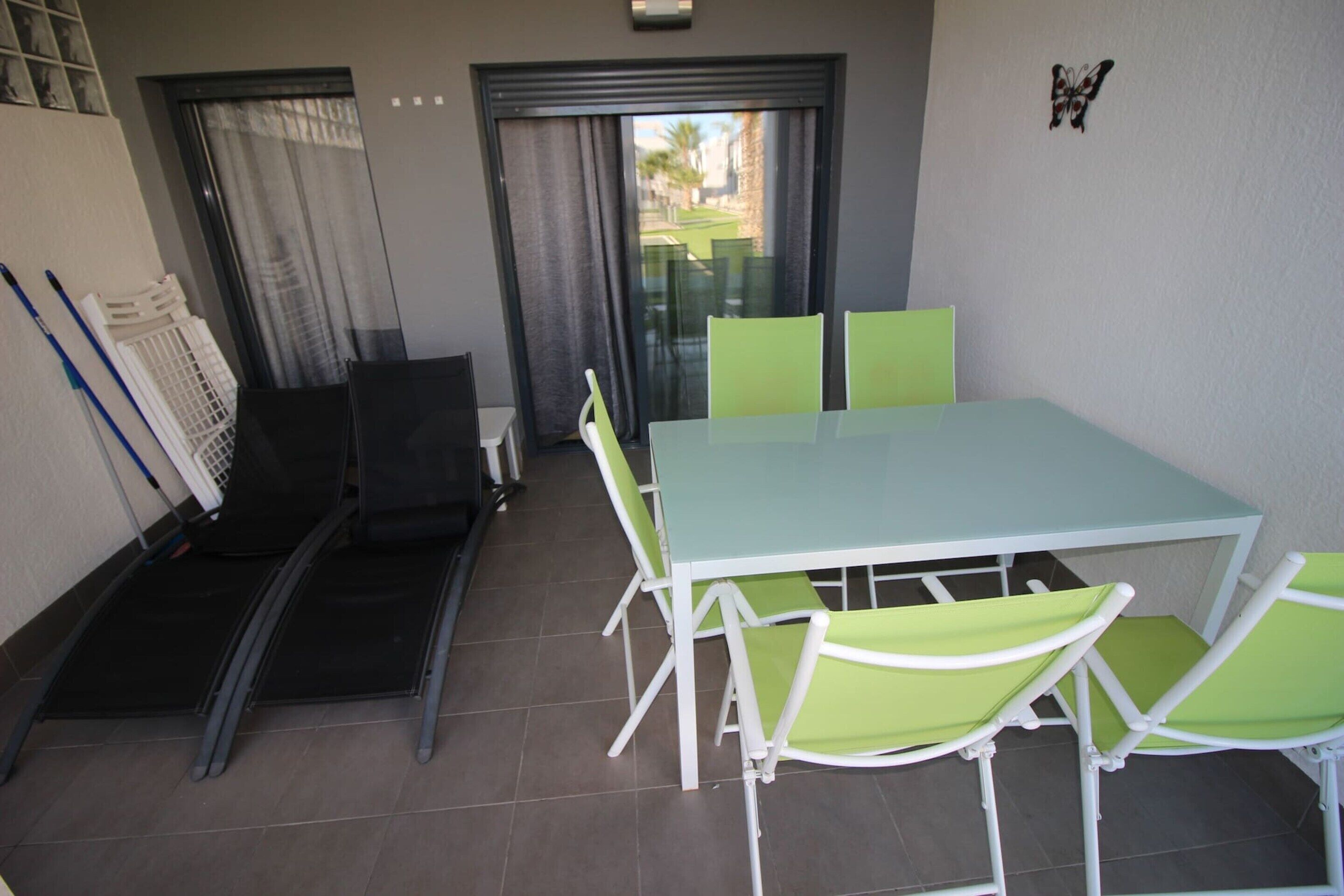 A dining area with a table and chairs, a sliding door, and a butterfly decoration on the wall.