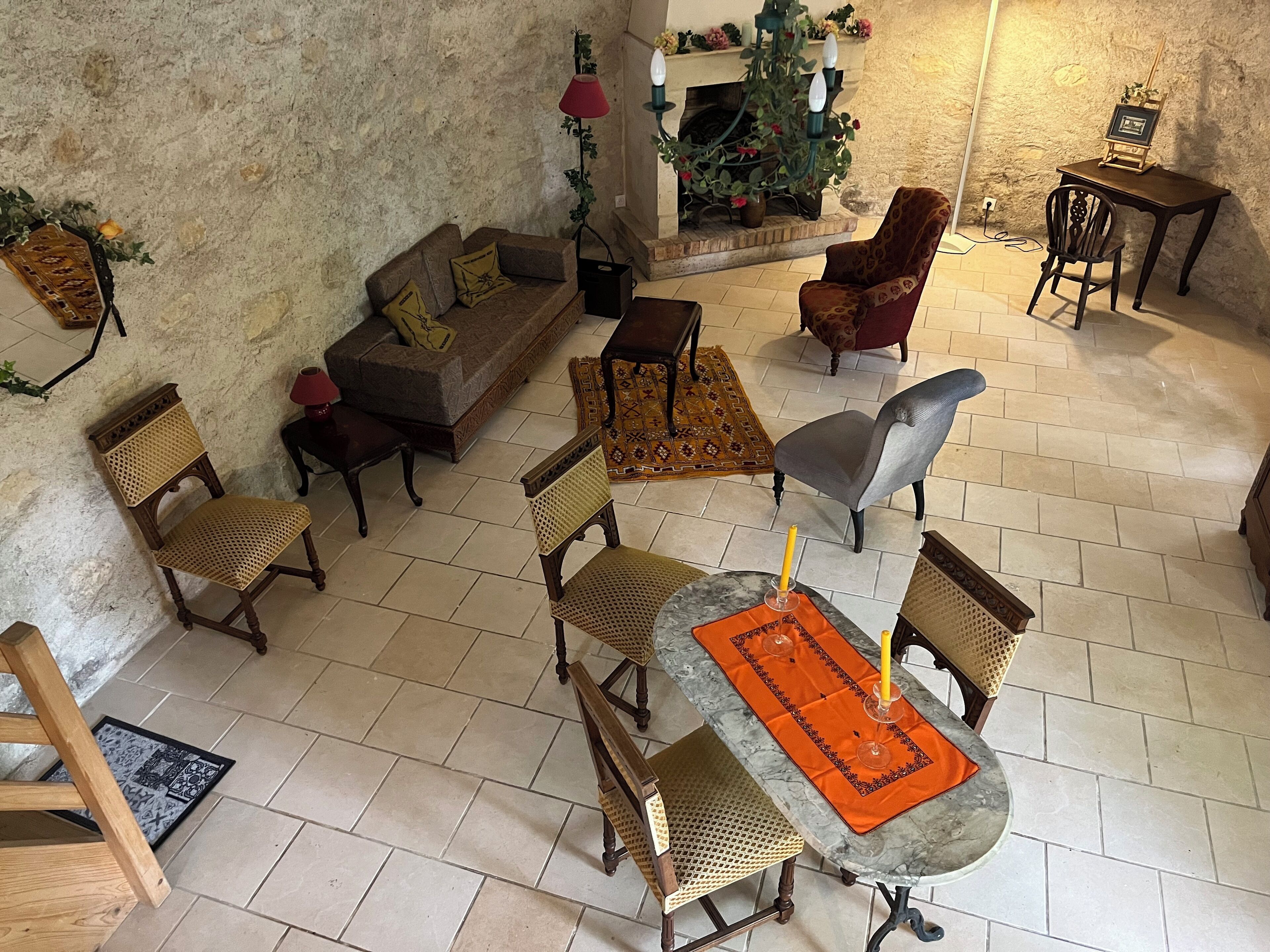 Una sala de estar acogedora con chimenea, una mesa de comedor con vela y diferentes opciones de asientos.