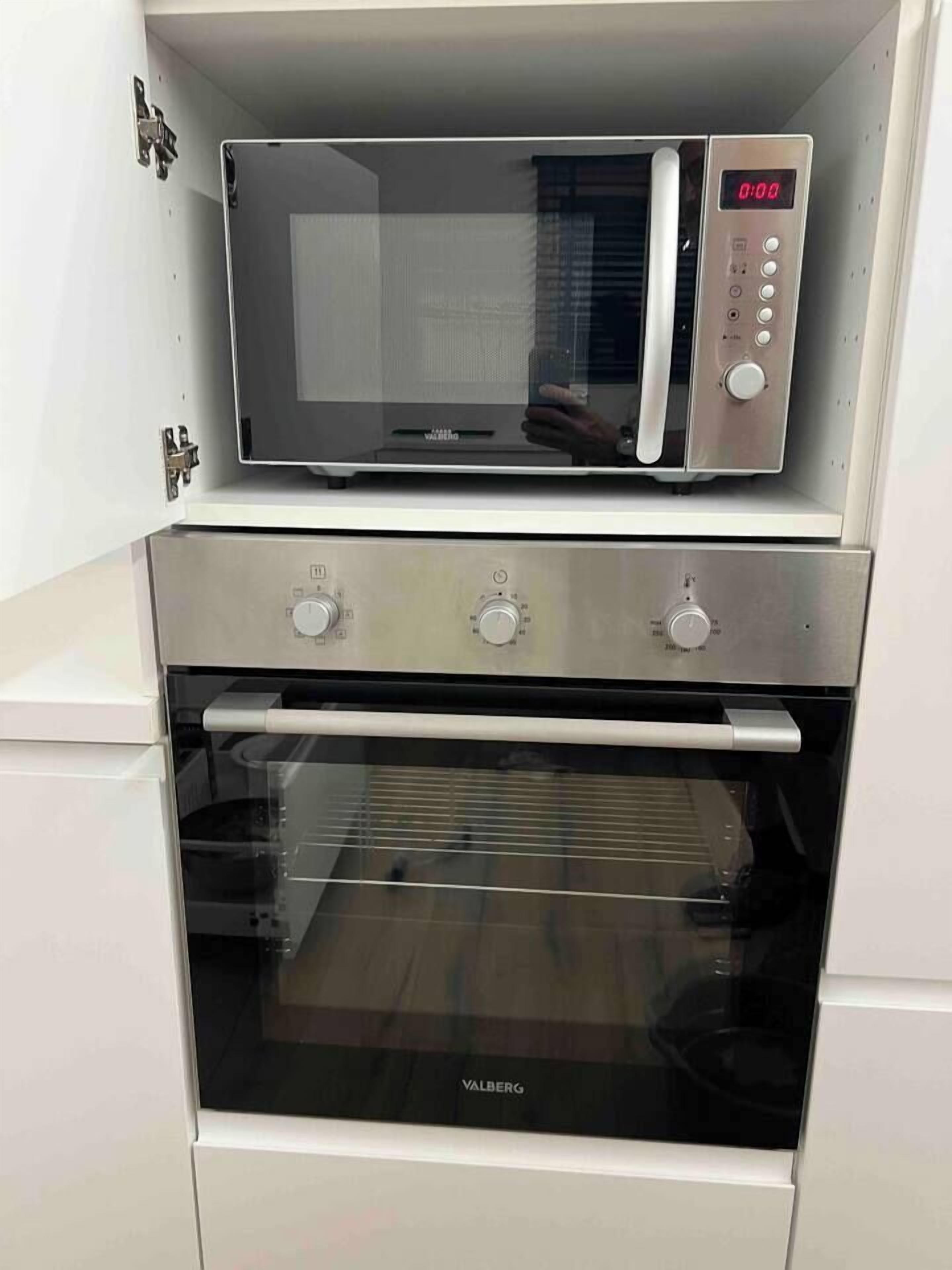 Una cocina compacta con horno y microondas integrados.